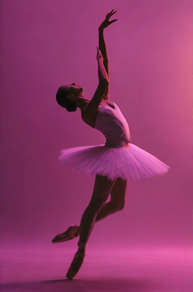 A ballerina reaching into pink stage light